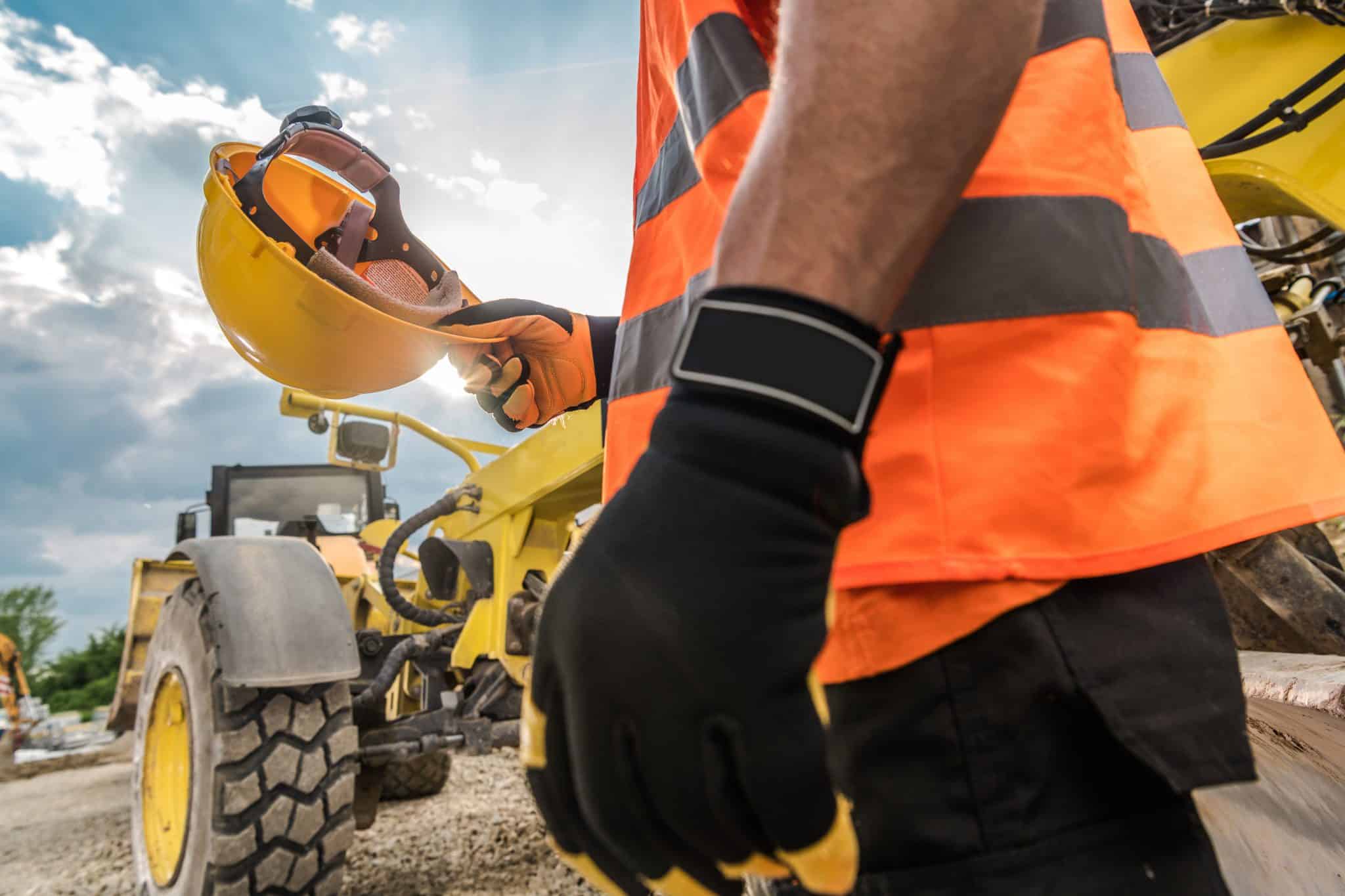 Hard Hat Construction Safety. Caucasian Heavy Duty Equipment Operator is About to Wear His Yellow Helmet.