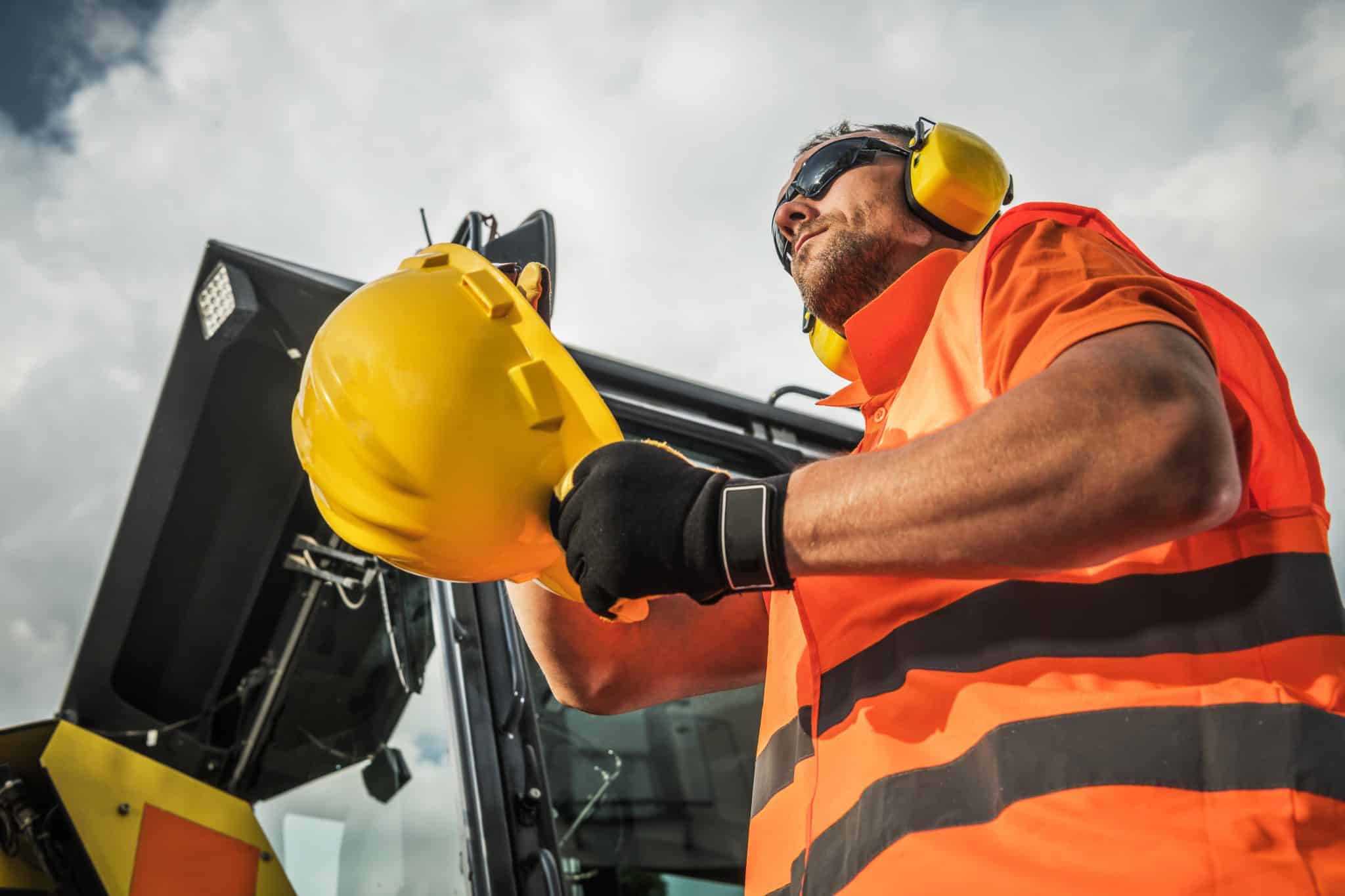 Caucasian Construction Contractor Wearing Protection Accessories. Hard Hat and Noise Reduction Headphones.